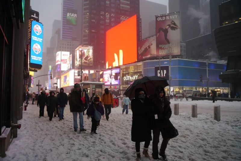 Pedestrians walking through snow in Times Square